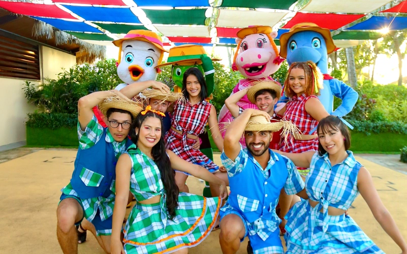 a imagem mostra os personagens da Turma do Parque com um grupo vestido de São João para celebrar a programação junina especial do Beach Park