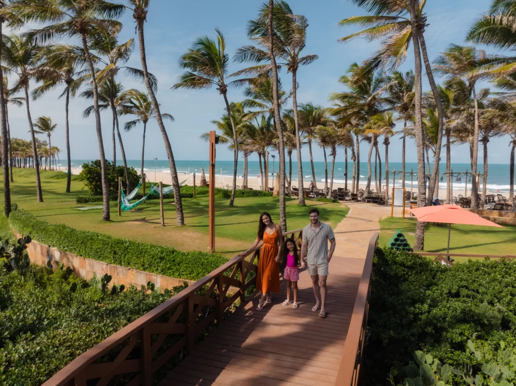 a imagem mostra uma família aproveitando o resort Beach Park em frente ao mar da Praia do Porto das Dunas, no Ceará, próximo à Fortaleza