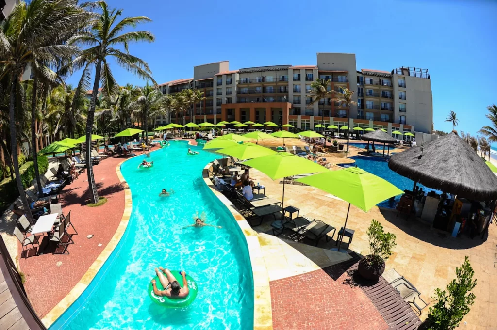 a imagem mostra uma visão panorâmica do Acqua Beach Park Resort, com os apartamentos e as pessoas na piscina que tem ligação com o parque aquático