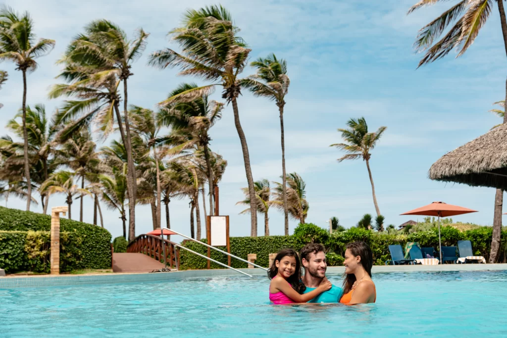 a imagem mostra um casal e uma criança na piscina de um dos quatro resorts Beach Park se divertindo