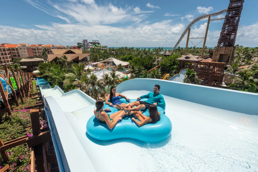 a imagem mostra um grupo de pessoas sorridentes em uma boia de uma das atrações do Aqua Park, Beach Park, em Aquiraz