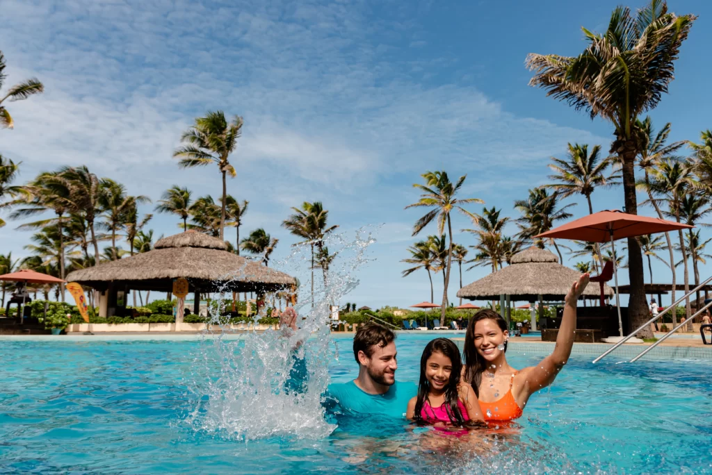 a imagem mostra uma família se divertindo na piscina de um dos Resorts do Beach Park, aproveitando a promoção Momento Insano