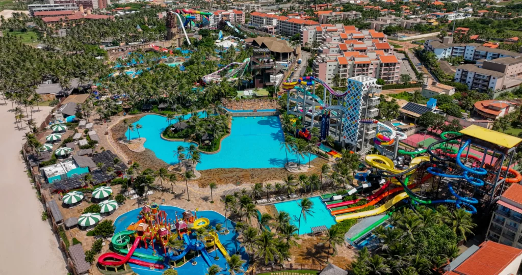 a imagem mostra uma foto panorâmica do destino Beach Park, que envolve parque aquático, arvorar, resorts e vila azul do mar, além de restaurante na praia do porto das dunas