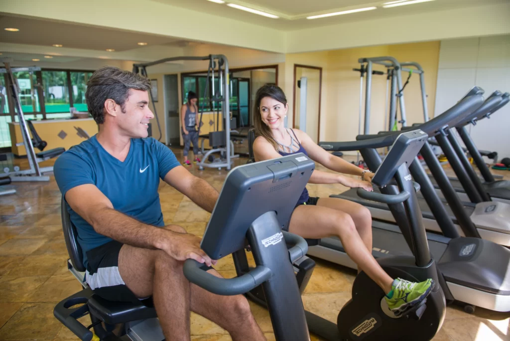 a imagem mostra um casal fazendo atividade física no espaço fitness do Suites Beach Park Resort, na Praia do Porto das Dunas