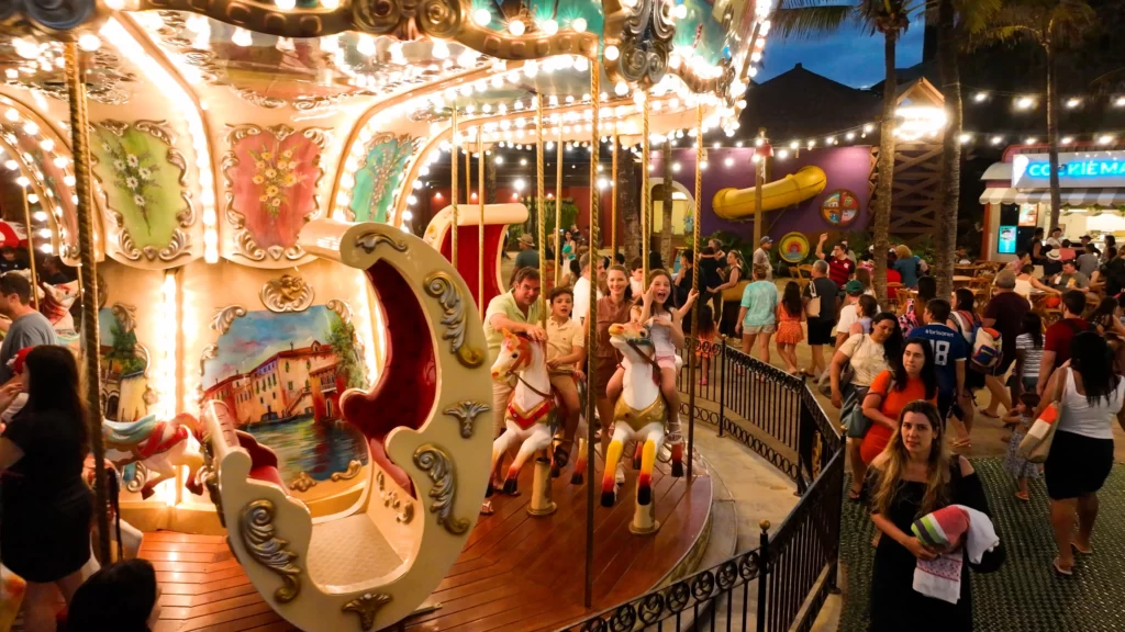 a imagem mostra uma família aproveitando a noite na Vila Azul do Mar, com atrações e uma programação cultural gratuita para adultos e crianças