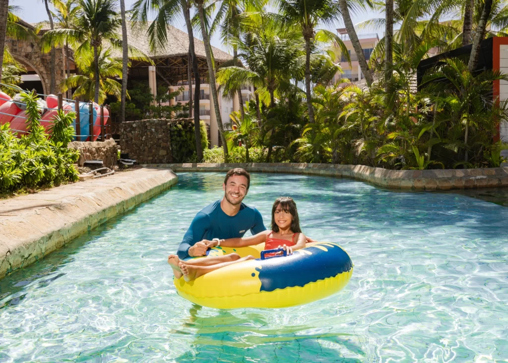 a imagem mostra uma criança em uma boia com o pai na corretenza, atração do aqua park, no beach park